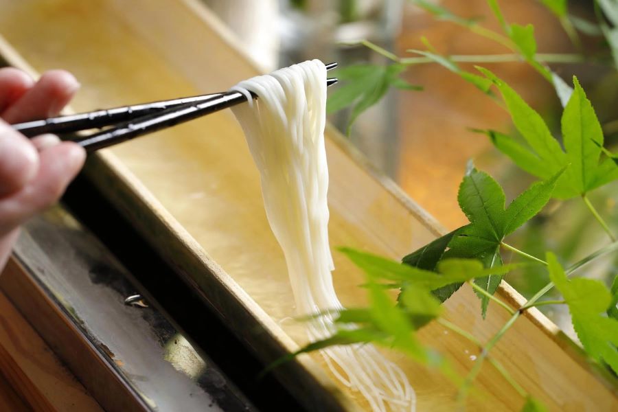 Món mì somen được thả trôi trên ống tre, tạo nên một trải nghiệm thú vị và độc đáo