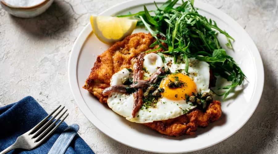 Schnitzel có vỏ ngoài vàng ươm, giòn rụm được tẩm bột mì, chiên ngập trong dầu, ẩn chứa bên trong là lớp thịt bê mềm mại, ngọt lịm