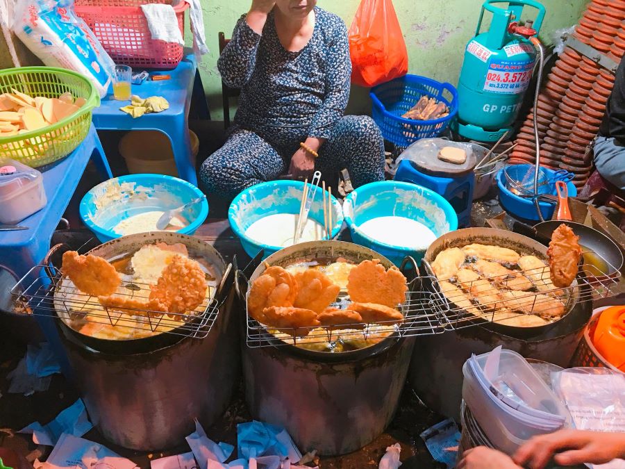 Những chiếc bánh vàng tươi, xèo xèo trong chảo dầu lớn