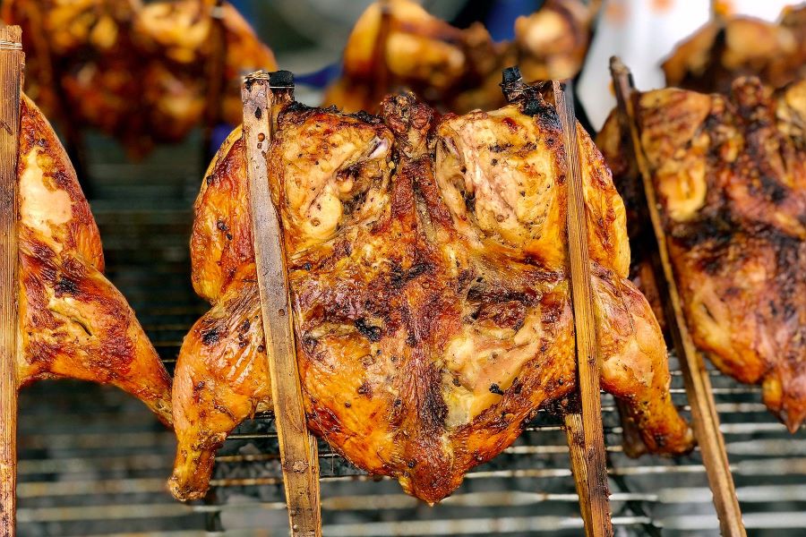 Gà nướng của người Lào được ướp với nhiều loại gia vị khác nhau và nướng nguyên con trên bếp than hồng 